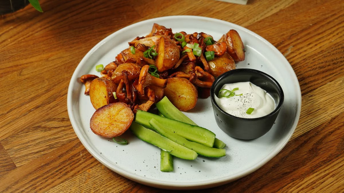 A delectable plate of roast potatoes served with chanterelle mushrooms and fresh cucumbers.